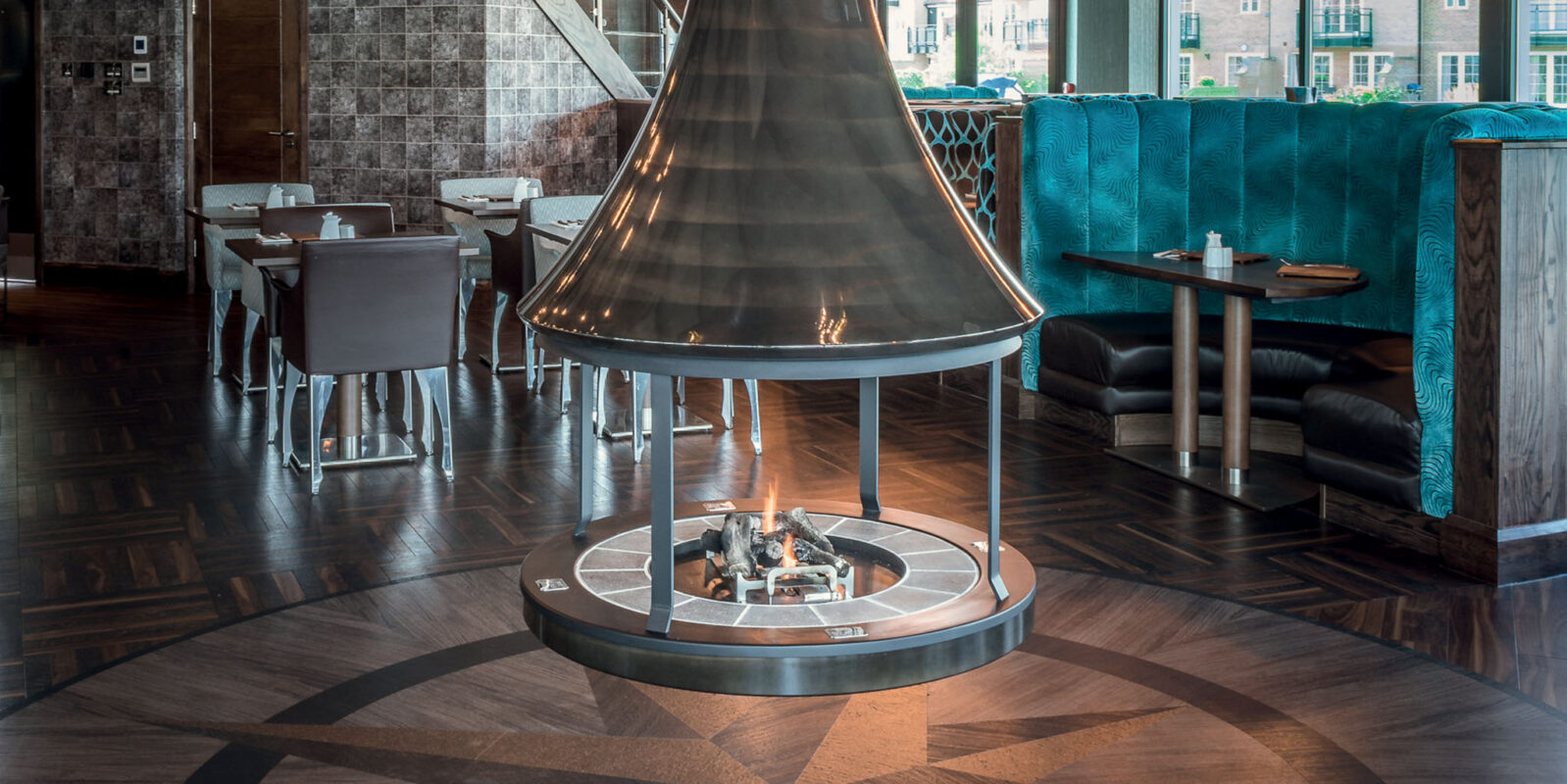 Clear Varnish JC Bordelet Zelia Luxury Suspended Fireplace in a stylish cafe.